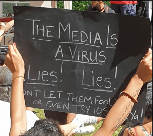 Protestors' banner - "The Media Is A Virus"