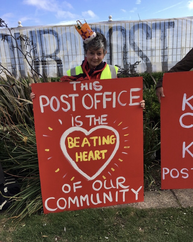Julia wearing one of a set of crowns made by one of the campaigners - to emphasise the community’s campaign to save the integrity of St Leonards Crown Post Office. Her placard: This PO is the beating heart of our community