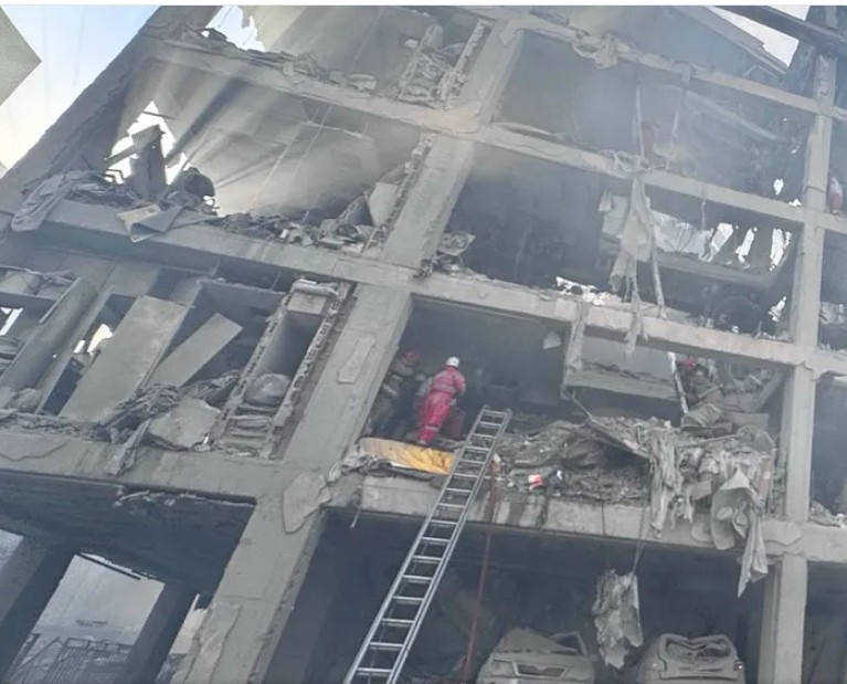 Rescue workers climbing into bombed out flats