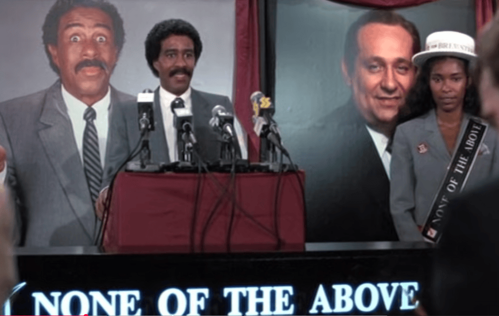 Brewster speaks in an election campaign with 'X none of the above' as his slogan.